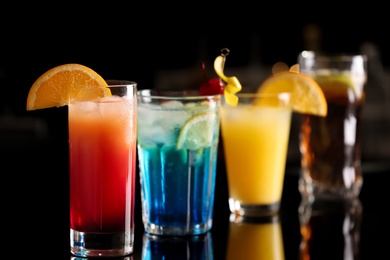 Photo of Different delicious cocktails on counter in bar