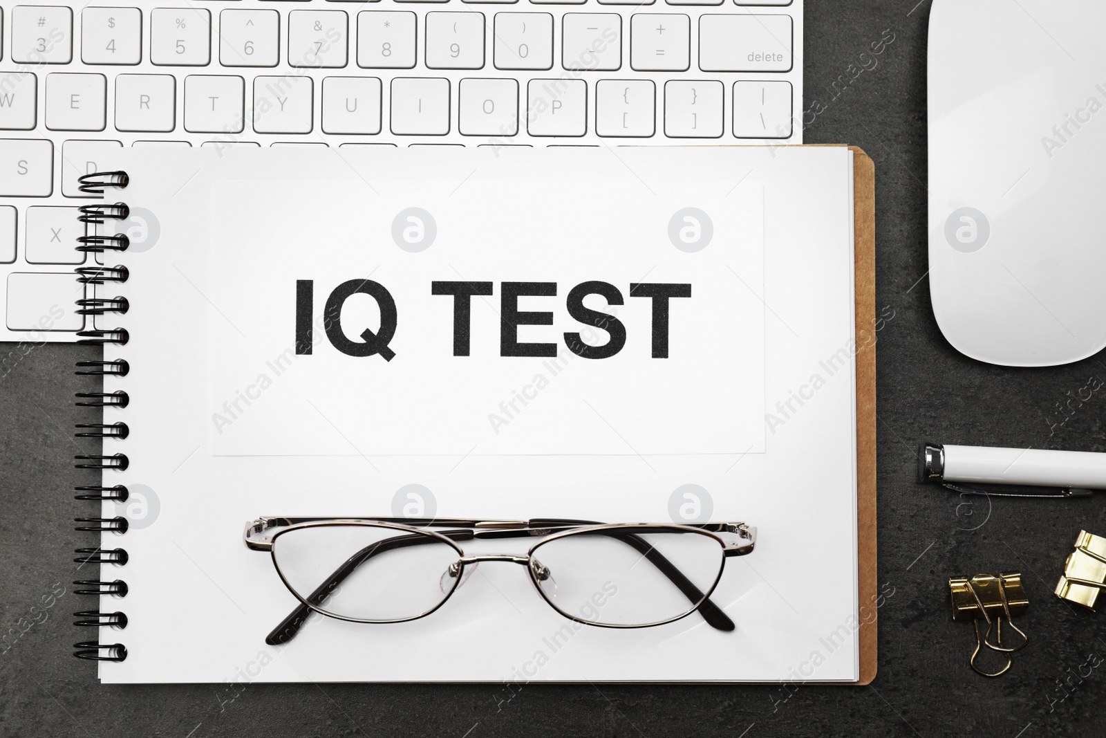 Photo of Notebook with words IQ Test, keyboard and glasses on black table, flat lay