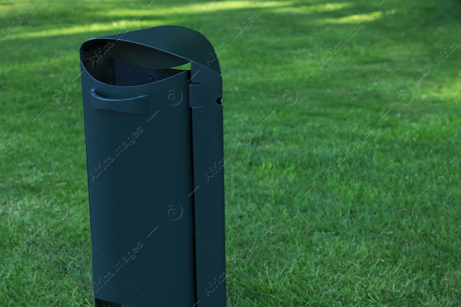 Photo of Trash bin on green grass outdoors. Space for text