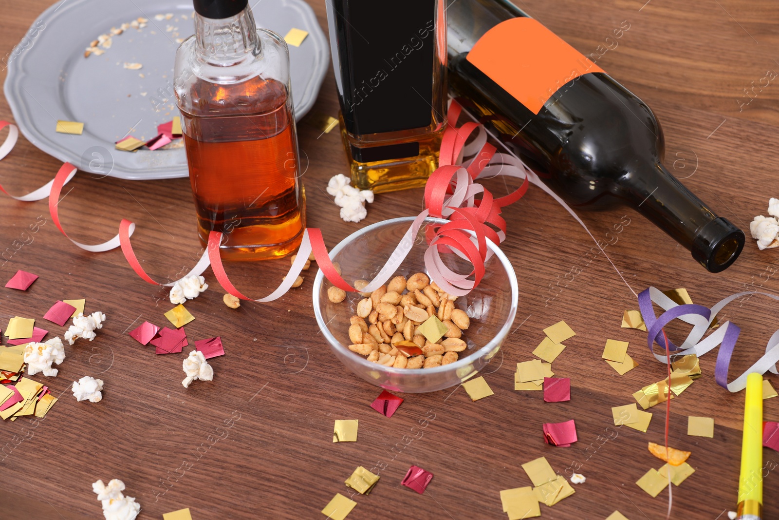 Photo of Messy table with popcorn, bottles and streamers after party