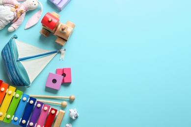 Flat lay composition with different toys on light blue background. Space for text
