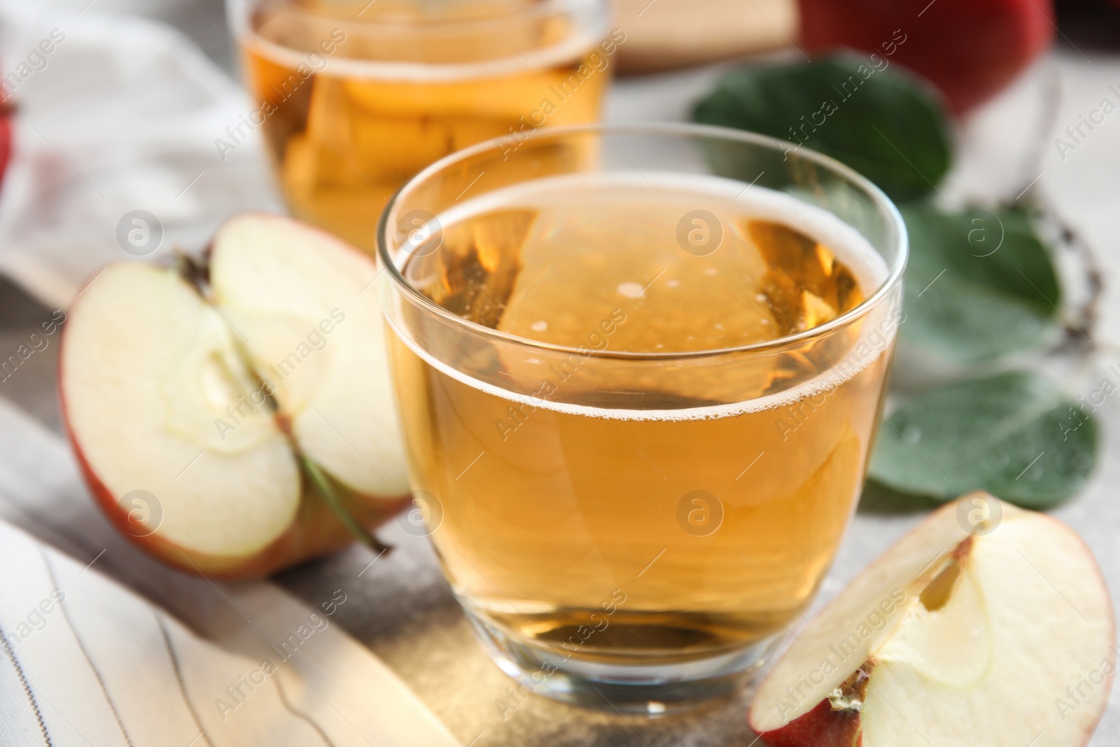 Photo of Delicious cider and ripe apple on table, closeup