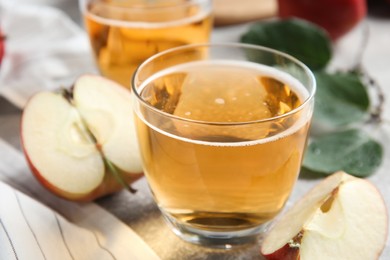 Photo of Delicious cider and ripe apple on table, closeup