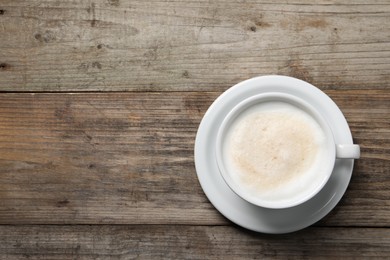 Photo of Aromatic coffee in cup on wooden table, top view. Space for text