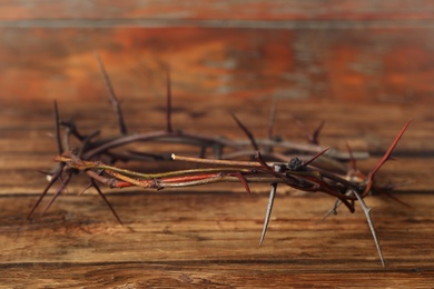 Crown of thorns on wooden table, space for text. Easter attribute