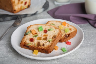 Photo of Delicious cake with candied fruits on light grey table