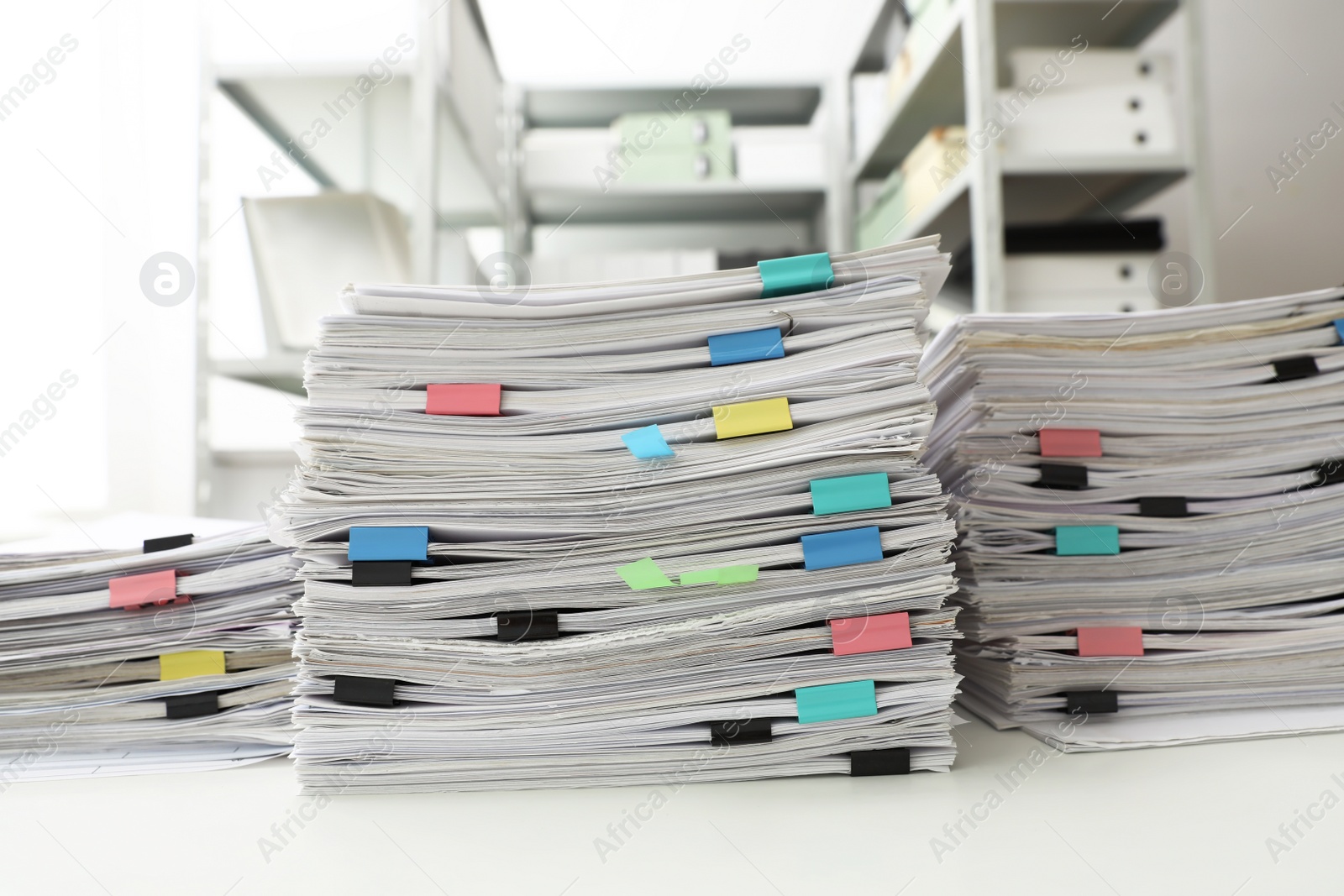 Photo of Stacks of documents with paper clips on office desk
