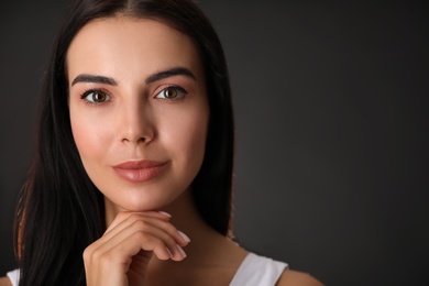 Portrait of beautiful young woman on black background