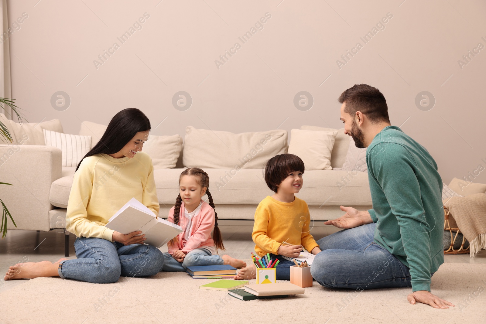 Photo of Happy family spending time together on floor in living room