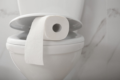 Photo of Paper roll on toilet bowl in bathroom