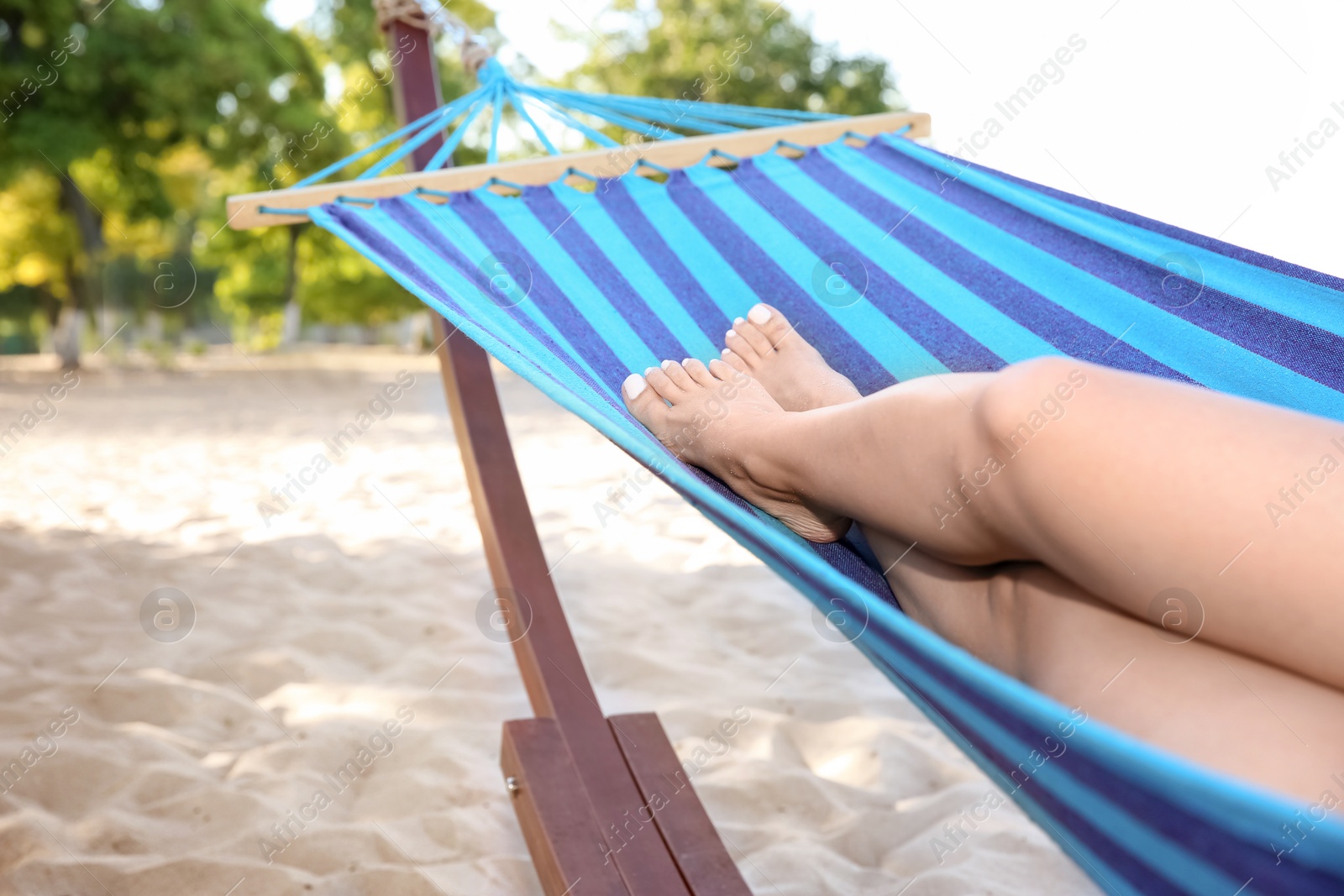 Photo of Young woman relaxing in comfortable hammock at seaside