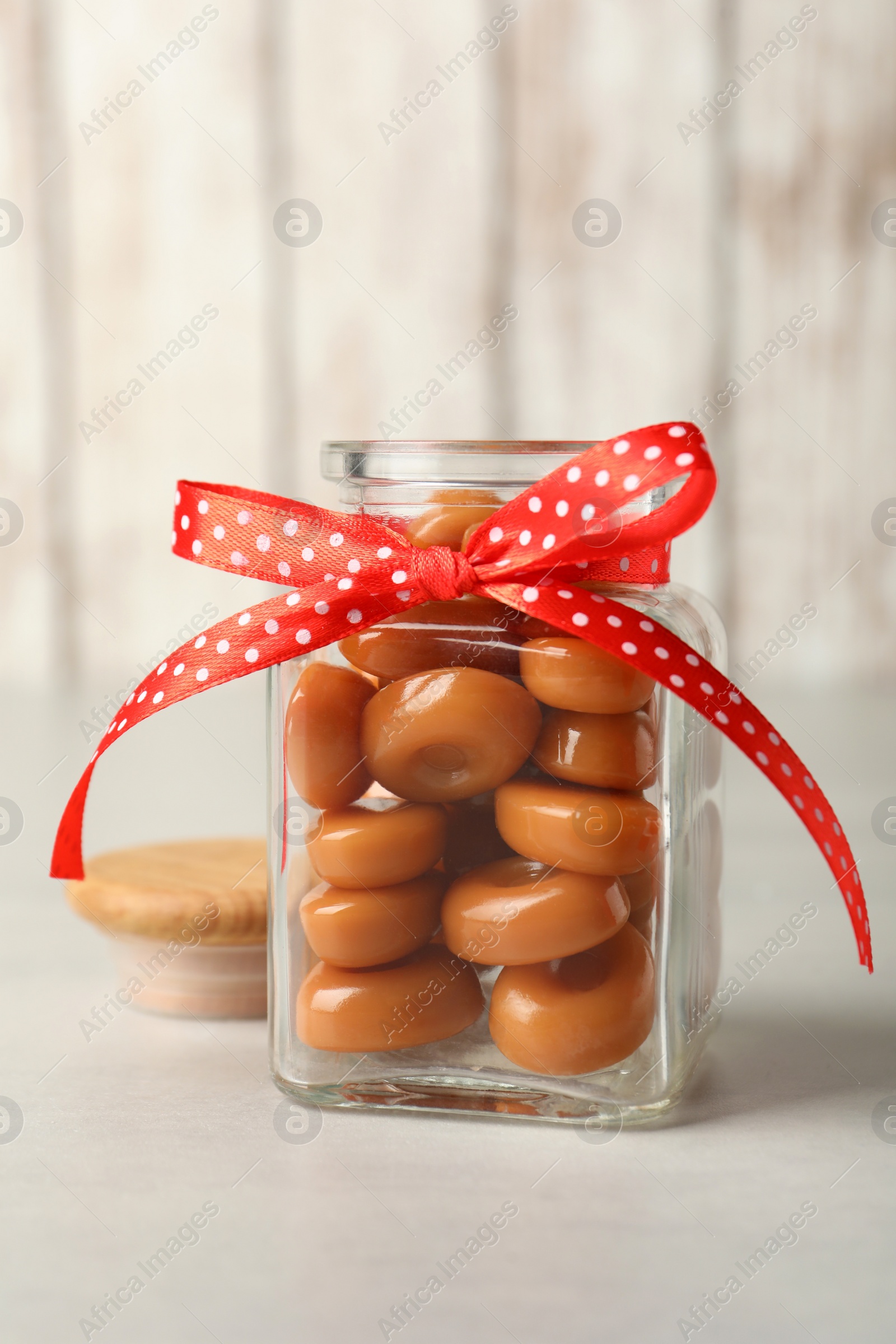 Photo of Sweet candies in jar on light grey table