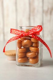 Photo of Sweet candies in jar on light grey table