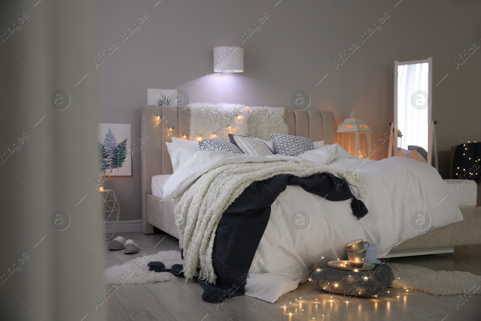 Photo of Cozy bedroom interior with warm blanket and cushions