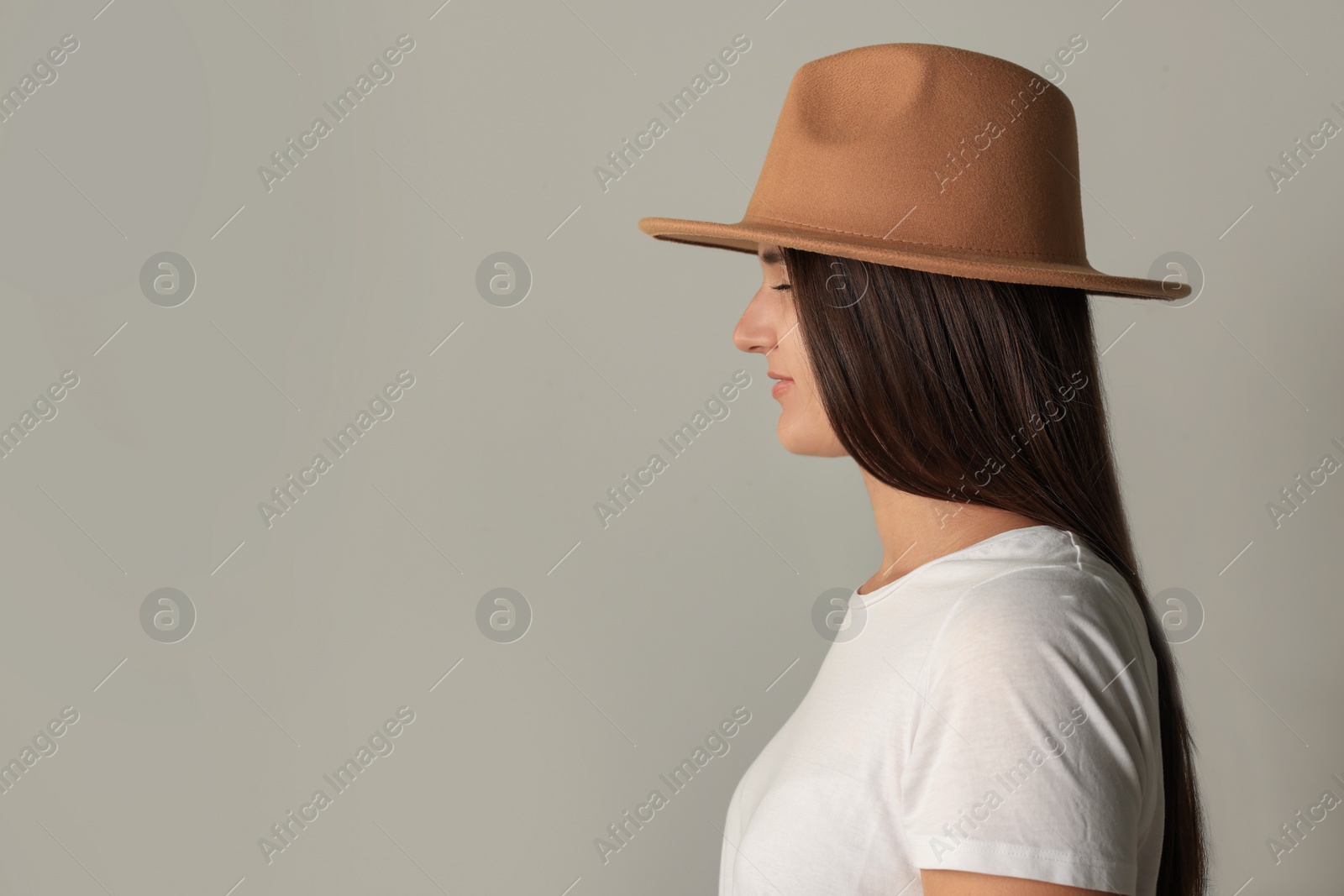 Photo of Young woman with closed eyes in stylish outfit on light grey background. Space for text