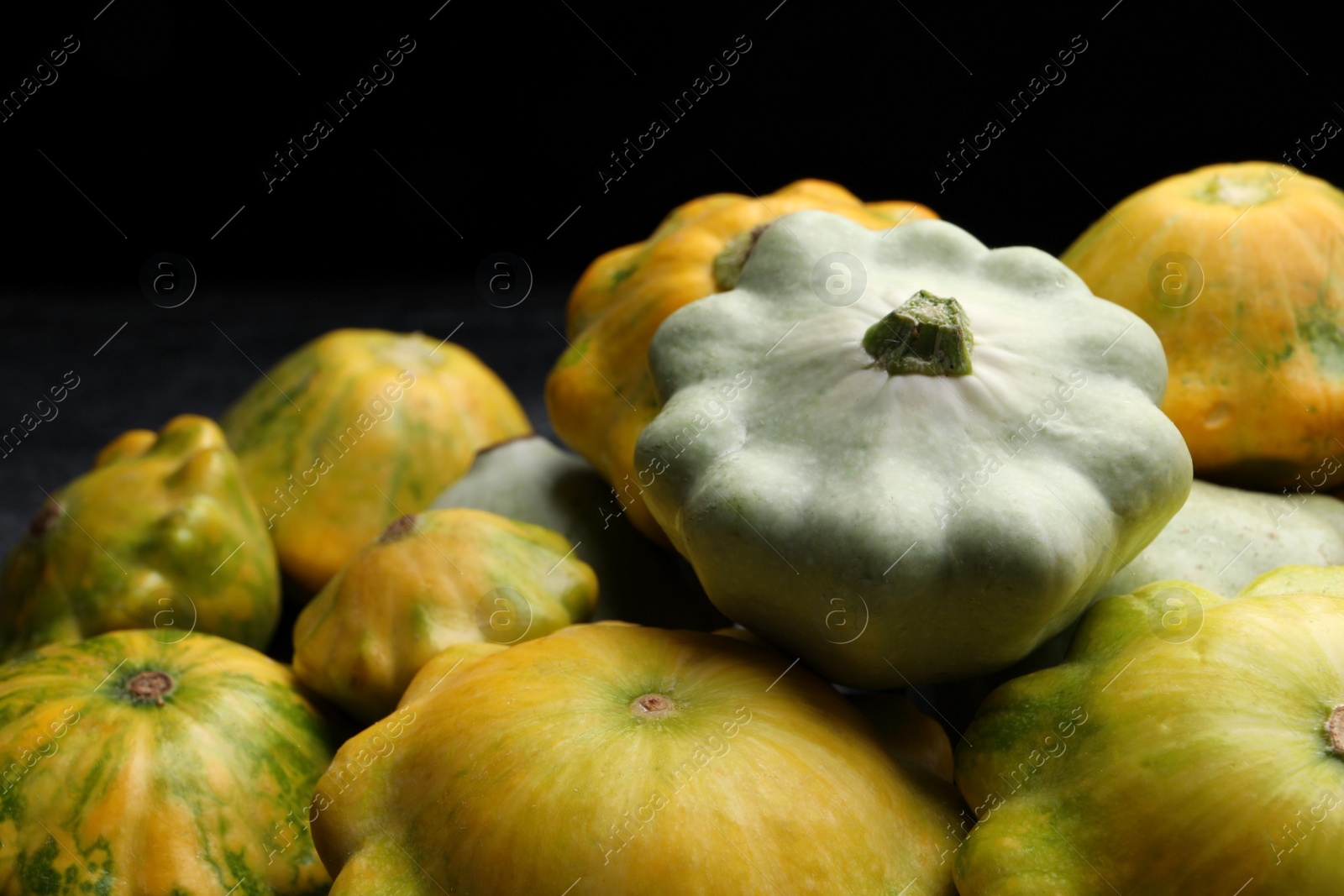 Photo of Fresh ripe pattypan squashes on dark background, closeup