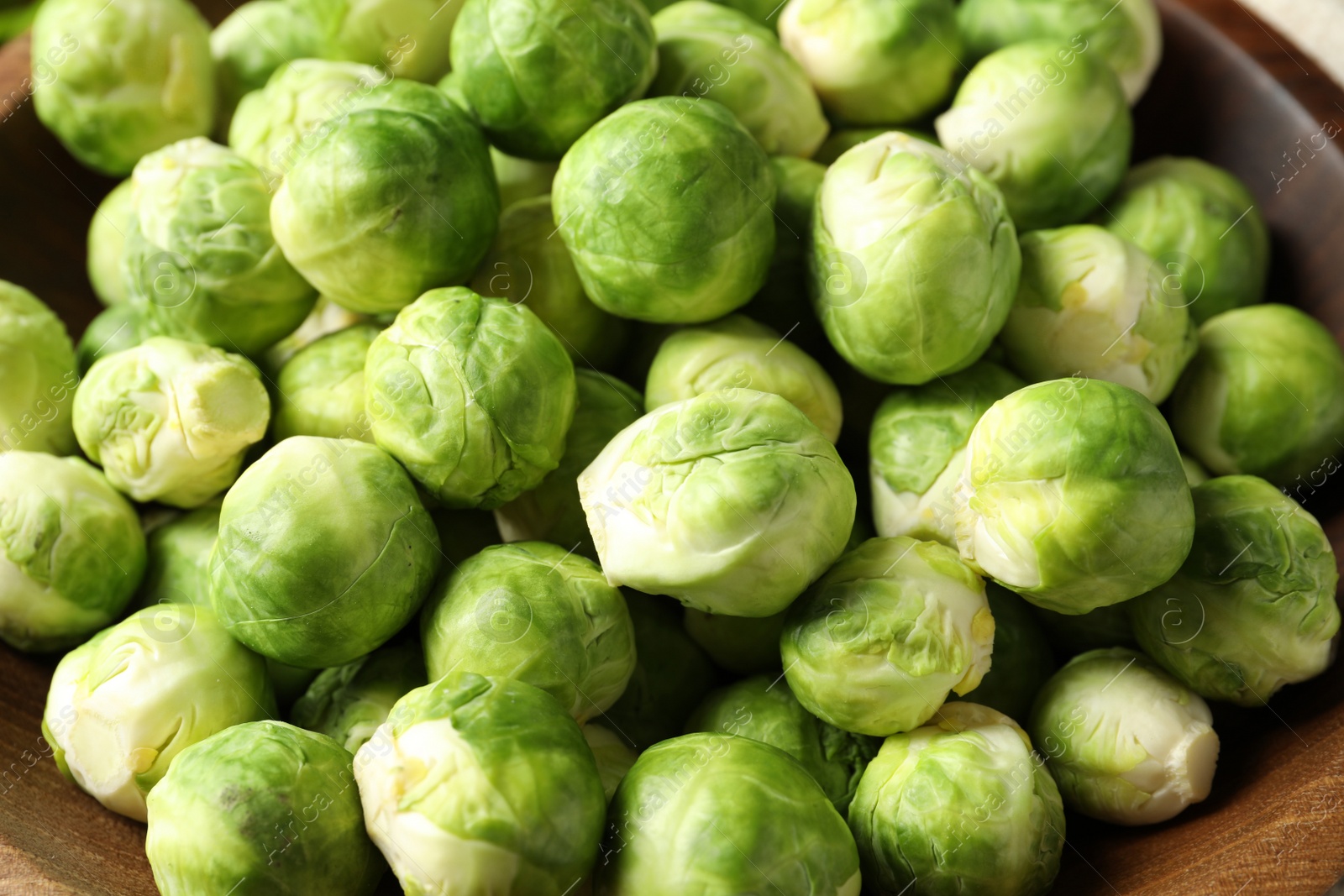 Photo of Tasty fresh Brussels sprouts in bowl, closeup