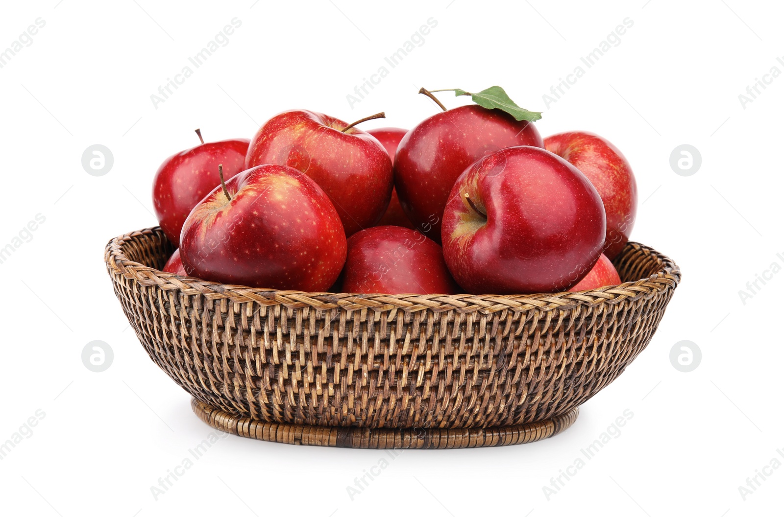 Photo of Wicker bowl of ripe juicy red apples with leaf on white background