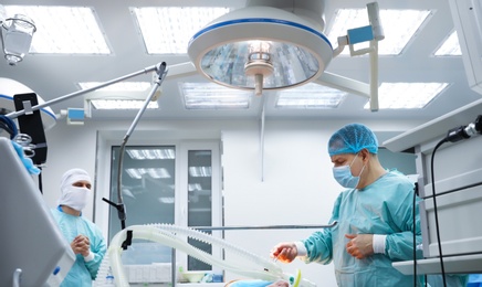 Photo of Doctor preparing patient for surgery in operating room