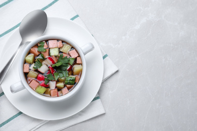 Delicious cold okroshka with kvass served on light grey table, top view and space for text. Traditional Russian summer soup