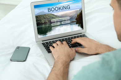 Man using laptop to plan trip, closeup. Travel agency website