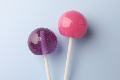 Tasty lollipops on light blue background, flat lay