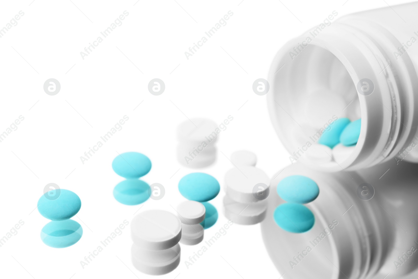 Photo of Bottle with different pills on mirror surface