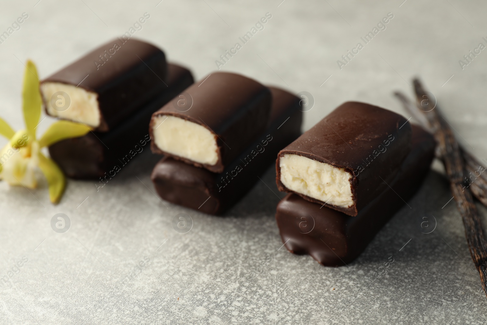 Photo of Glazed vanilla curd cheese bars on grey table, closeup