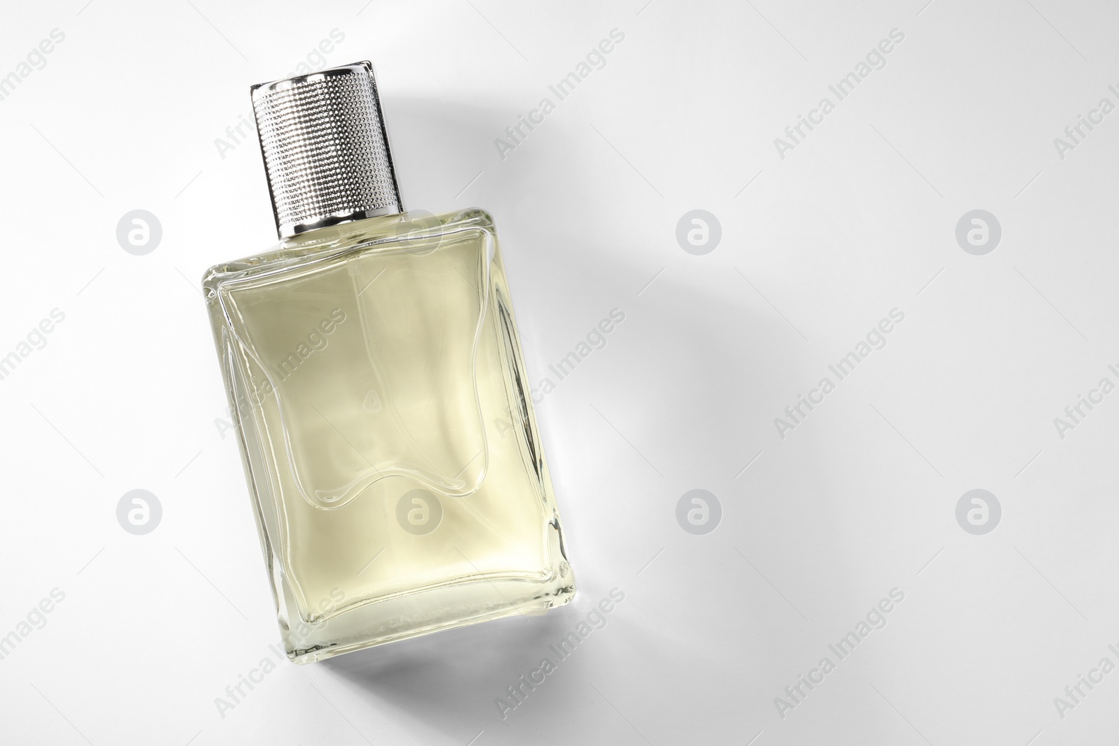 Photo of Luxury men`s perfume in bottle on white background, top view. Space for text