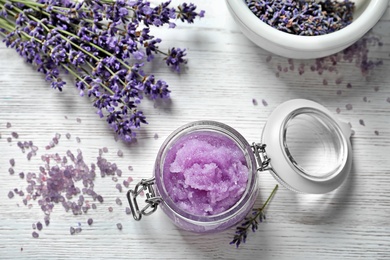 Flat lay composition with natural sugar scrub and lavender flowers on white wooden table. Cosmetic product