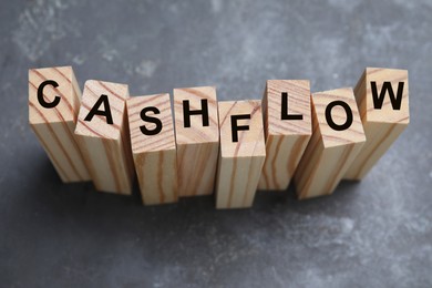 Wooden blocks with phrase Cash FLow on grey background, above view