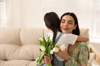 Photo of Little daughter congratulating her mom at home. Happy Mother's Day