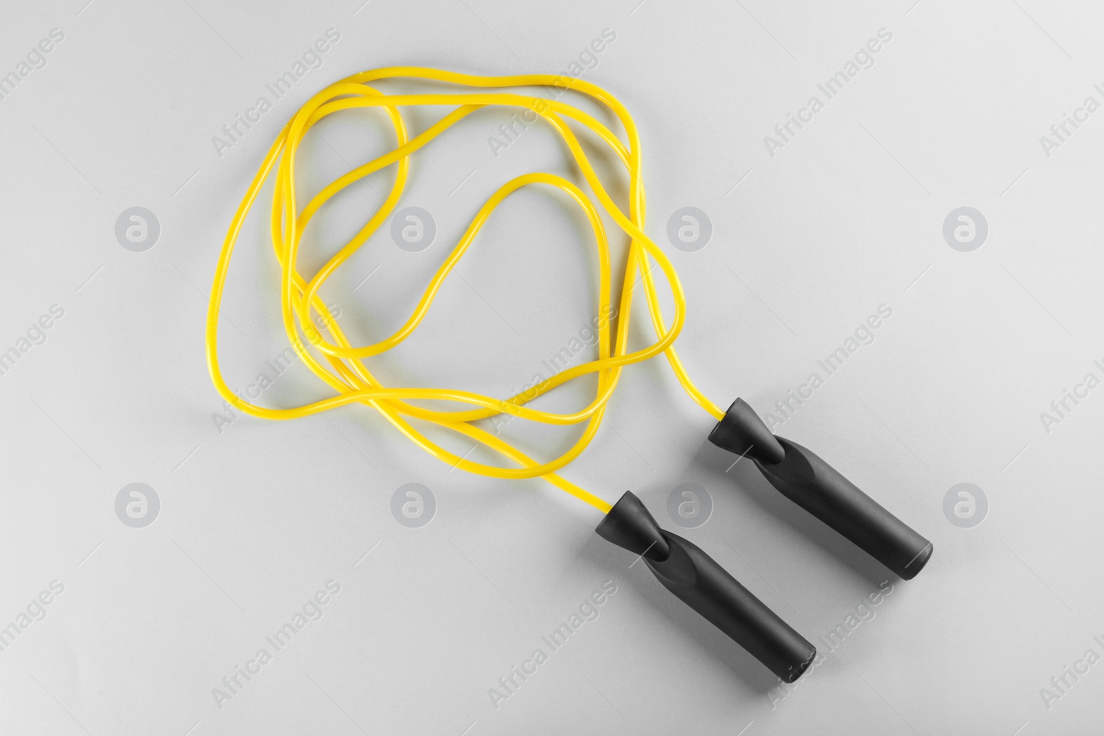 Photo of Skipping rope on light grey background, top view. Sports equipment