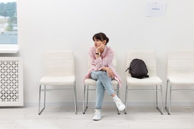 Photo of Woman sitting on chair and waiting for job interview indoors