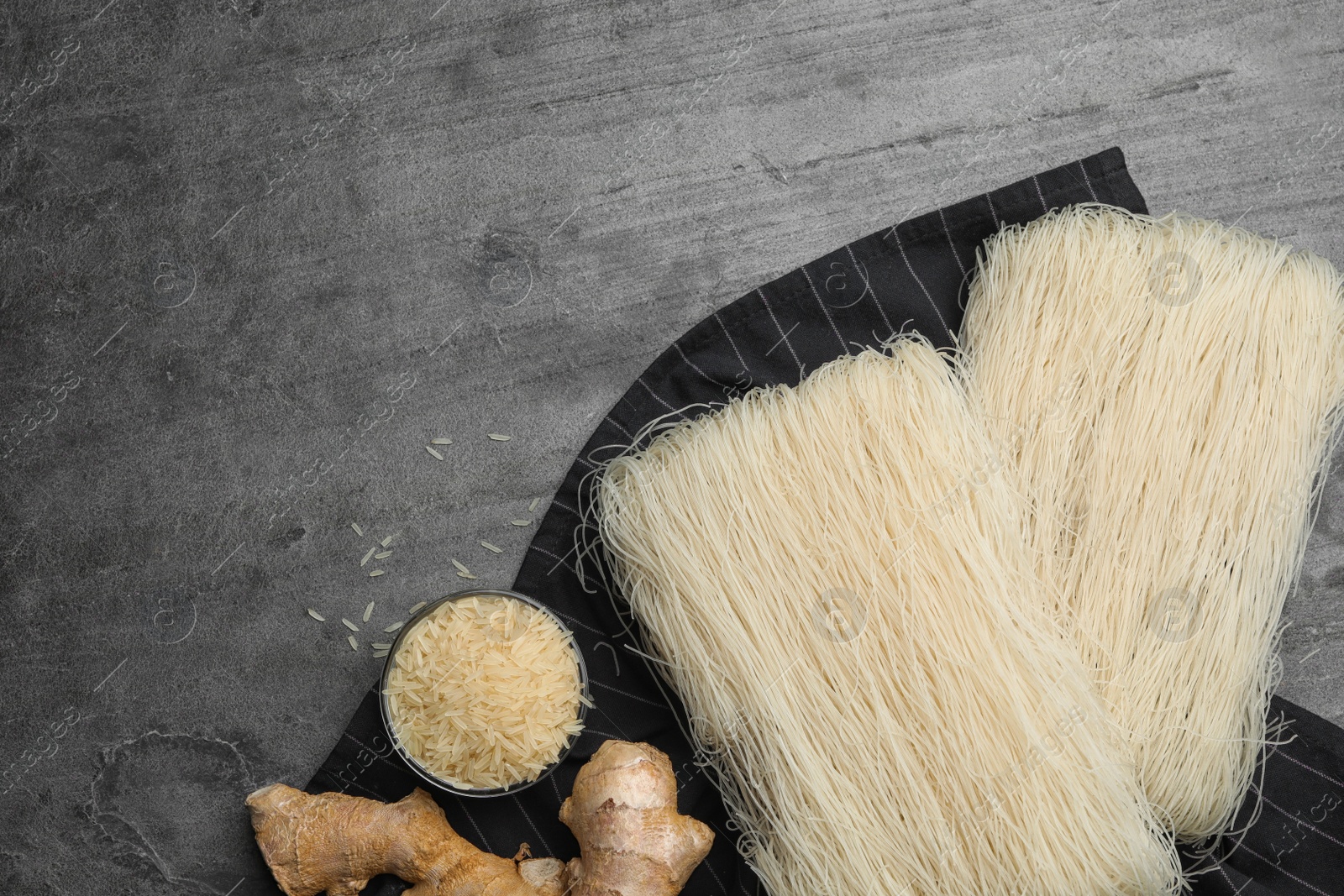 Photo of Flat lay composition with rice noodles on grey table, space for text