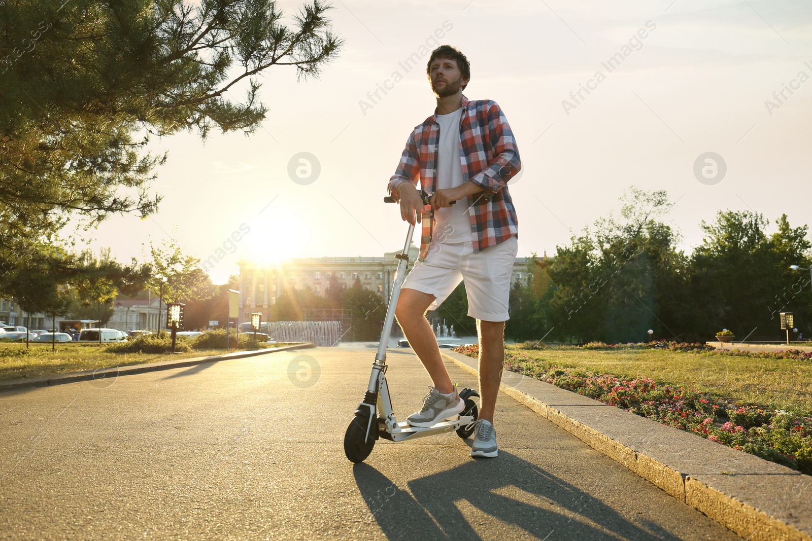 Photo of Man with kick scooter in sunny park