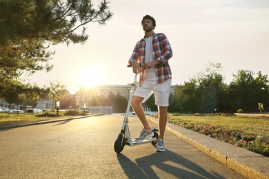 Man with kick scooter in sunny park