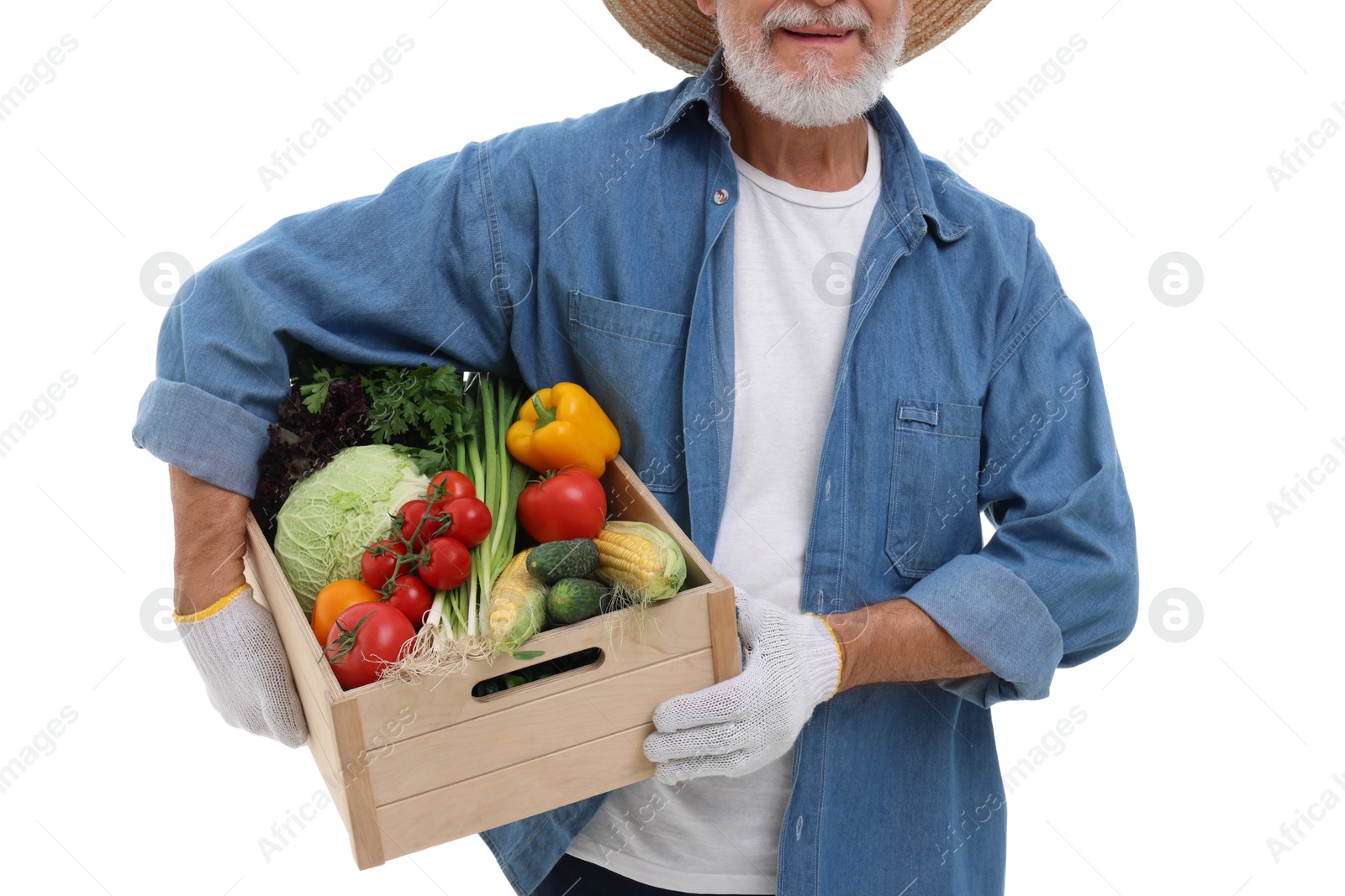 Photo of Harvesting season. Happy farmer holding wooden crate with vegetables on white background, closeup