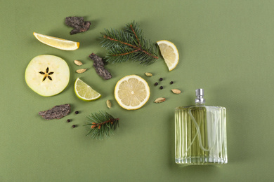 Photo of Flat lay composition with bottle of perfume on green background