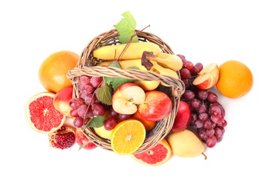 Photo of Wicker basket with different fruits on white background, top view