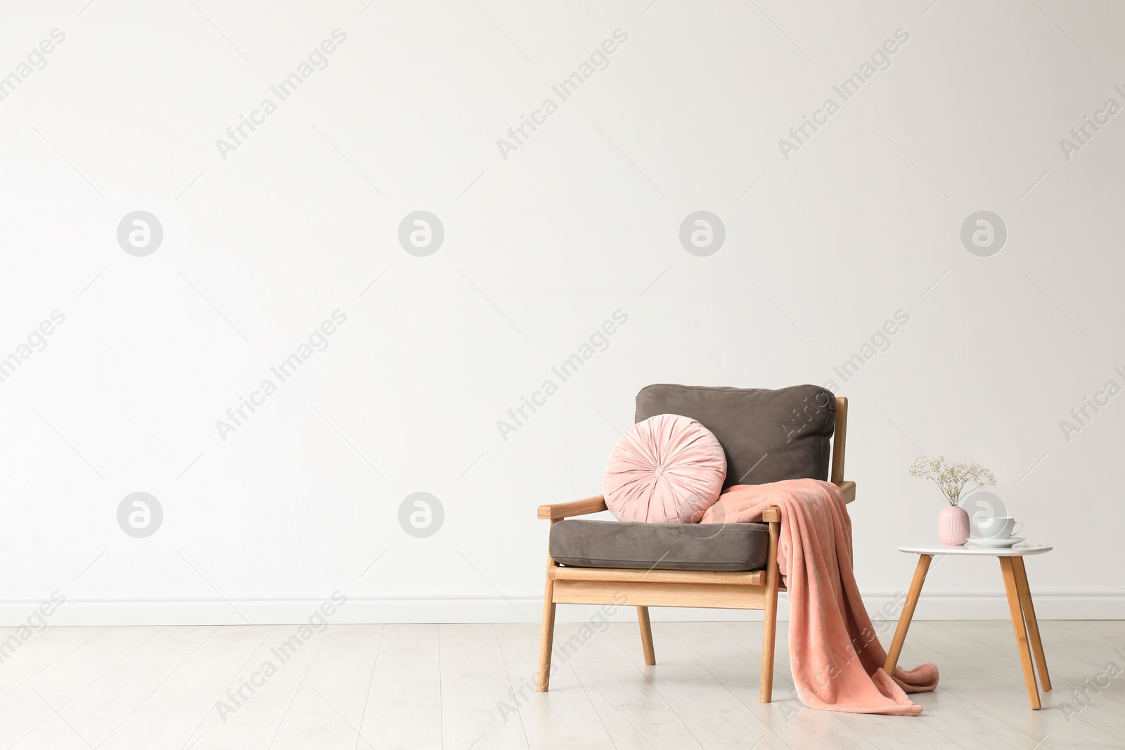 Photo of Stylish living room interior with comfortable armchair and wooden table near white wall. Space for text