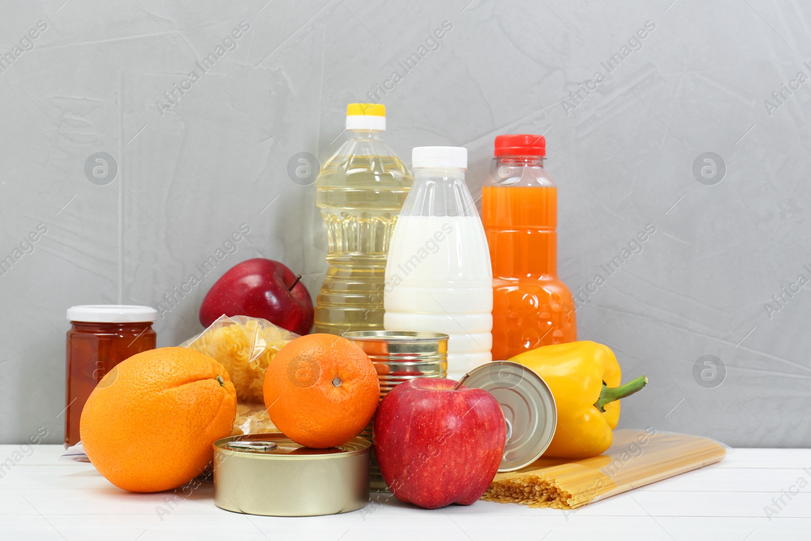 Photo of Humanitarian aid. Different food products for donation on white wooden table