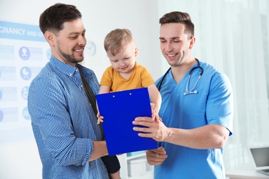 Photo of Father with child visiting doctor in hospital