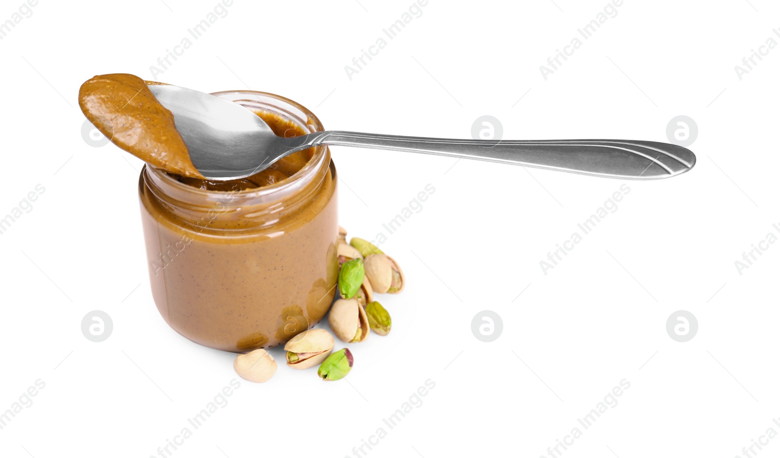 Photo of Tasty nut paste in jar, spoon and pistachios isolated on white