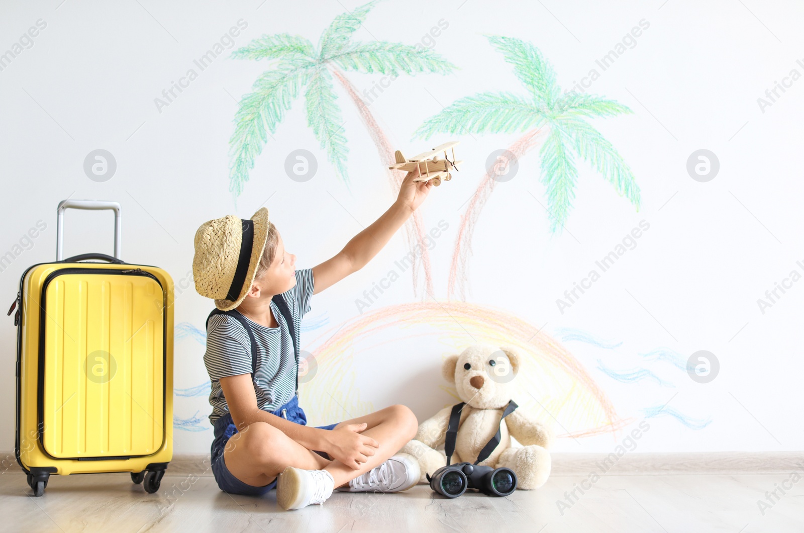 Photo of Adorable little child playing with toy airplane indoors