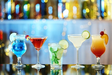Photo of Glasses of fresh alcoholic cocktails on bar counter