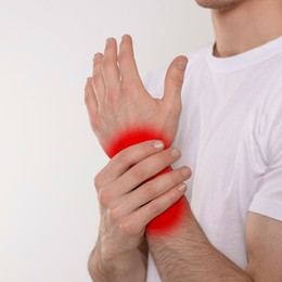 Man suffering from rheumatism on light background, closeup