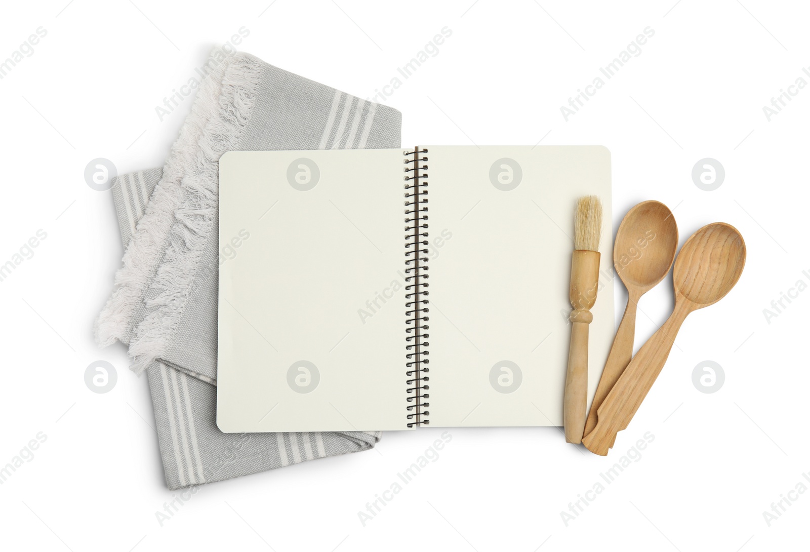 Photo of Blank recipe book, napkin and wooden utensils on white background, top view. Space for text