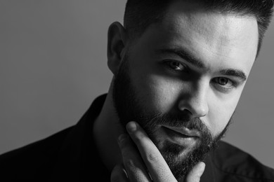 Portrait of handsome bearded man on grey background. Black and white effect