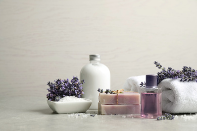 Photo of Cosmetic products and lavender flowers on light table